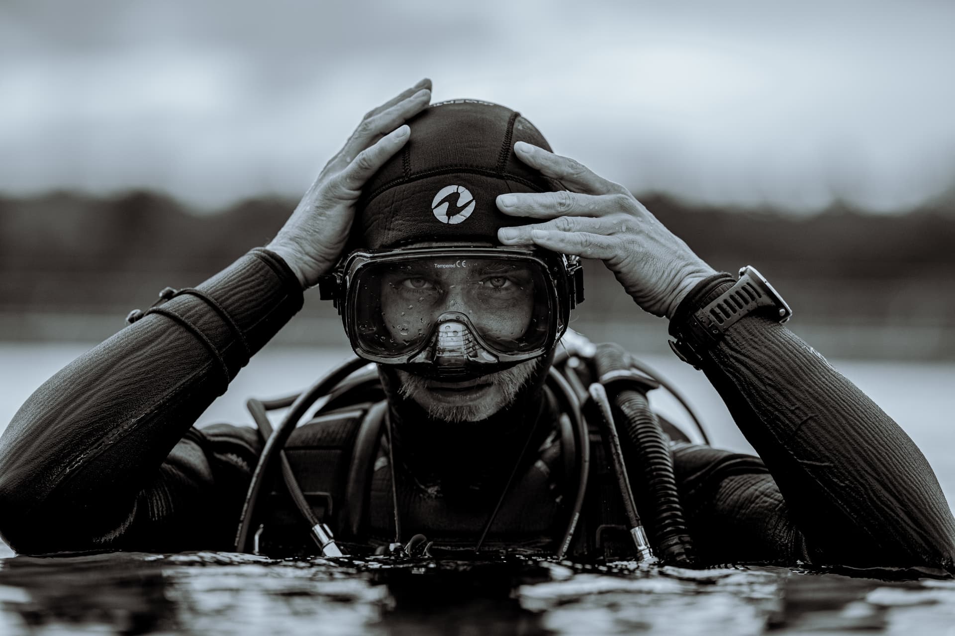 Taucher taucht mit Maske aus dem Wasser auf